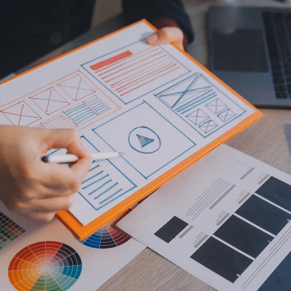 Hands sketch website wireframes with ruler and pen for Trumbull web design