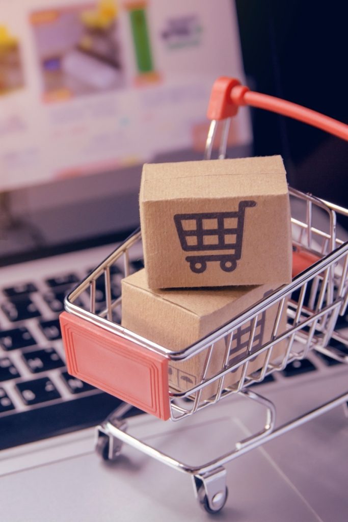 Tiny cart with small parcels sits across laptop keys for Trumbull e commerce
